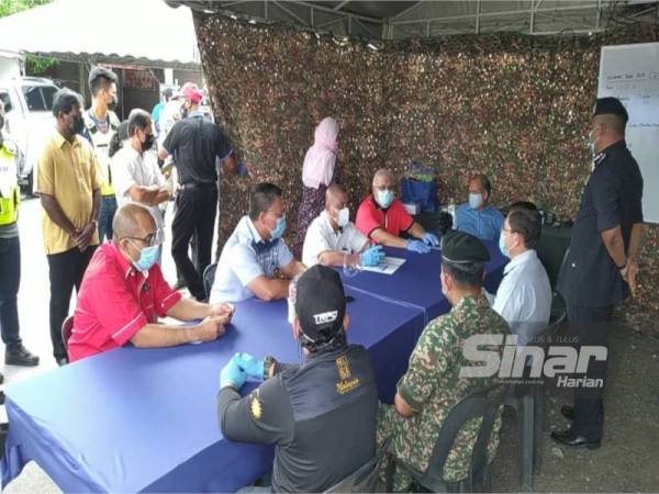 Saarani (duduk, tiga dari kiri) mendengar taklimat mengenai pelaksanaan PKPD di Taman Berkat, Matang, Taiping pada Selasa.