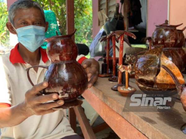 Yusran menunjukkan bekas minuman yang dihasilkan menggunakan dua tempurung.