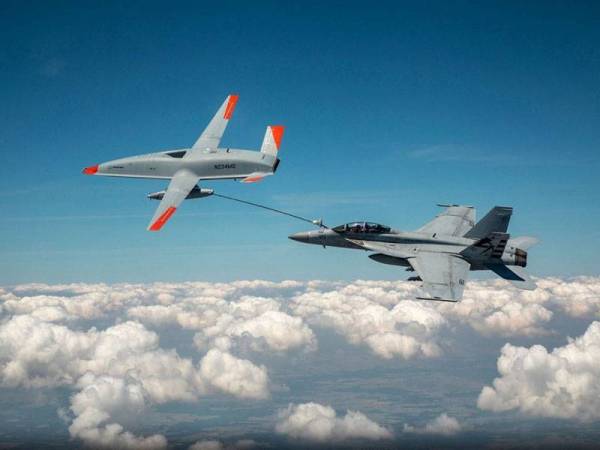 Sebuah dron tanpa juruterbang (depan) menyalurkan minyak dengan menggunakan hos untuk diisi ke dalam tangki jet tempur F/A-18 Super Hornet milik Tentera Laut Amerika Syarikat di ruang udara negara itu pada 4 Jun lalu. - Foto: AFP/Boeing