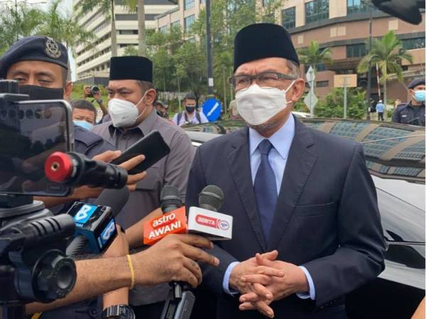 Anwar (kanan) ditemubual pemberita sejurus keluar dari pintu Istana Negara pada jam 11.54 pagi.