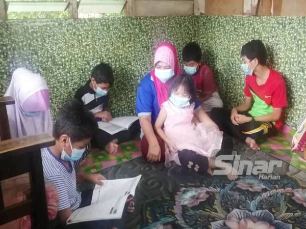 Hajirah (tengah) berharap keenam-enam anak saudaranya berpeluang menyambung pembelajaran mereka di sekolah.