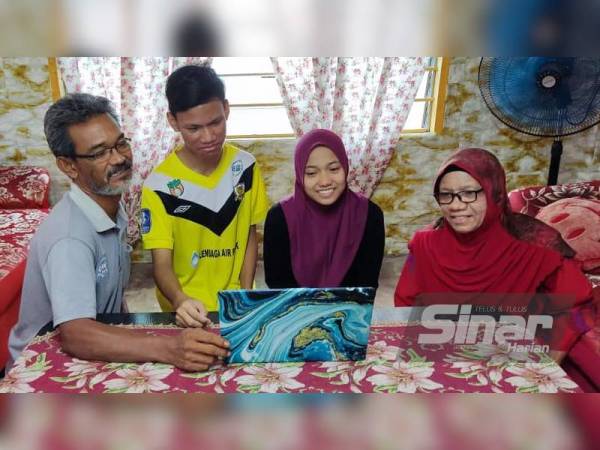 Dari kiri: Azman, Aliff Alimi, Aliya Nur Liyana dan Norzan melihat keputusan SPM 2020 anak mereka secara dalam talian di rumah mereka di Kepala Batas, Alor Setar pada Khamis.