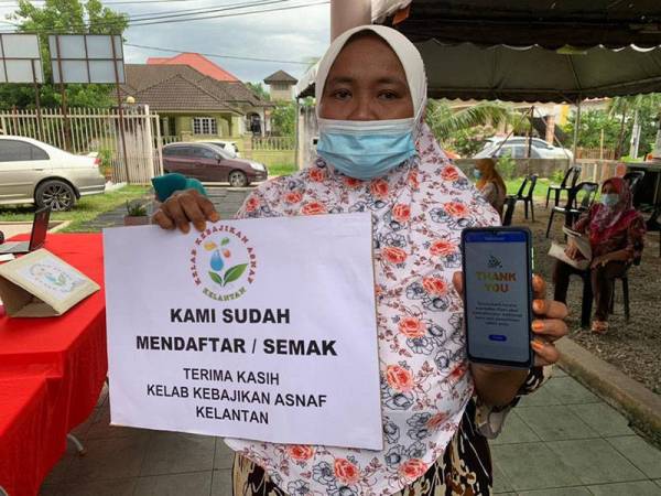 Ahli kelab, Siti Hulwani Mohammad menunjukkan MySejahatera yang telah diisi dengan bantuan kakitangan kelab berkenaan.