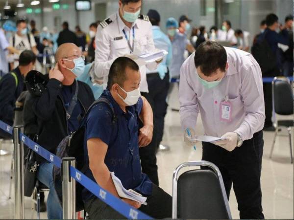 Pelawat dari China tiba di Lapangan Terbang Suvarnabhumi sebelum diarah menjalani kuarantin di kemudahan ASQ di Bangkok. - AFP