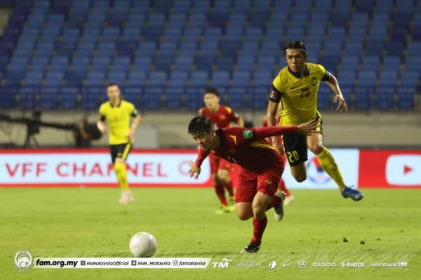 Syafiq (kanan) bersaing dengan pemain Vietnam pada aksi di Stadium Al Maktoum, Dubai sebentar tadi.