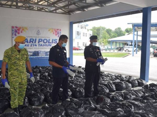 Shamsudin (kanan) menunjukkan rampasan daun ketum bernilai RM100,000 di Ibu Pejabat Polis Daerah Baling pada Ahad.