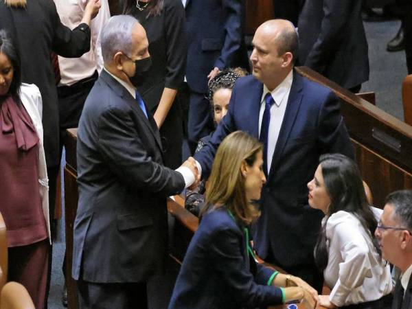 Netanyahu (kiri) bersalaman dengan Bennett selepas sesi undian khas di Knesset pada Ahad. - Foto: AFP