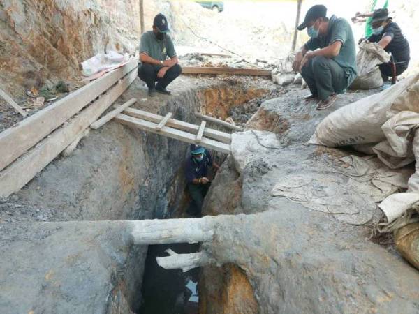 Anggota penguat kuasa JPNP meninjau lubang yang digali pelombong haram untuk mengaut tanah dan batu yang mengandungi emas di satu lokasi dalam kawasan Hutan Simpan Ibam, Muadzam Shah, Rompin pada operasi bermula Selasa hingga Khamis lalu. - Foto: JPNP