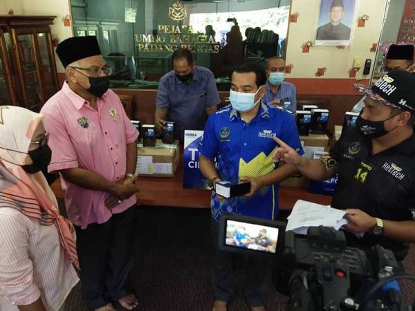 Ahmad Saidi (dua dari kanan) pada penyerahan 150 telefon pintar di bawah inisiatif Tuisyen Cikgu Saarani di Pusat Khidmat Dewan Undangan Negeri (DUN) Lubuk Merbau pada Isnin.