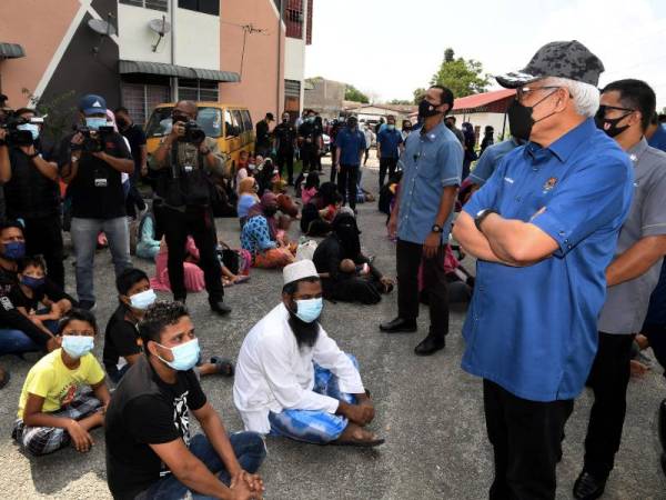 Hamzah (kanan) meninjau operasi yang dilakukan Jabatan Imigresen di Flat Jalan Terubuk, Seberang Jaya, Pulau Pinang pada Selasa. - Foto Bernama