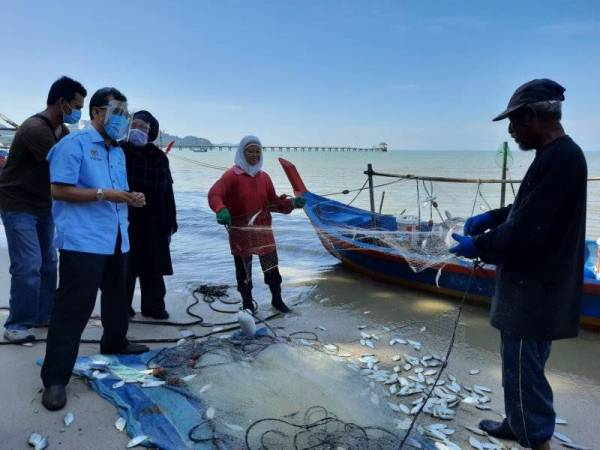 Che Abdullah (dua dari kiri) berbual dengan dua nelayan di Jeti Nelayan Teluk Kumbar dalam satu lawatan pada tengah hari Rabu.