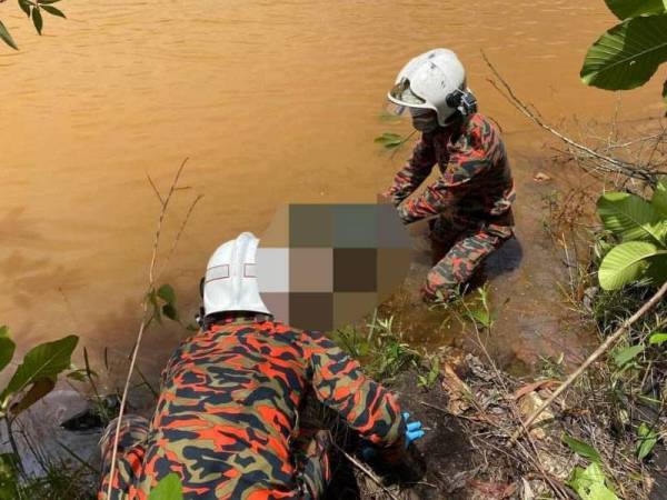 Anggota bomba menaikkan mayat lelaki berkenaan yang ditemui di dalam tasik berhampiran taman perumahan mangsa.