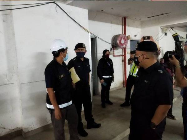 Mohamad Zainal (dua kiri) berbincang dengan Mohamad Faisal dalam operasi bersepadu di sebuah tapak pembinaan pangsapuri mewah di sini pada Sabtu.