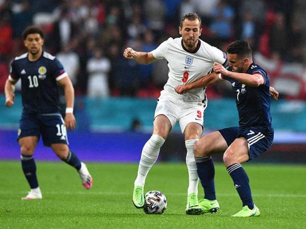 Kane (tengah) dikawal ketat pemain Scotland, John McGinn pada aksi kumpulan D Euro 2020 di Stadium Wembley. FOTO: AFP