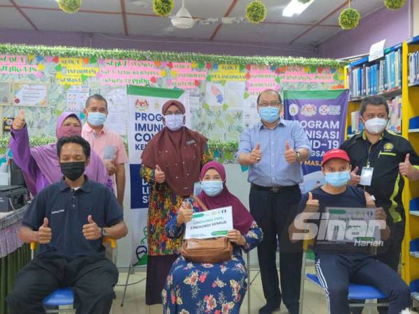 Dr Nor Azimi (tengah) bersama Ahmad Amzad meninjau Pusat Pemberian Vaksin (PPV) di Masjid At-Taqwa, Kampung Durian Burung pada Sabtu.