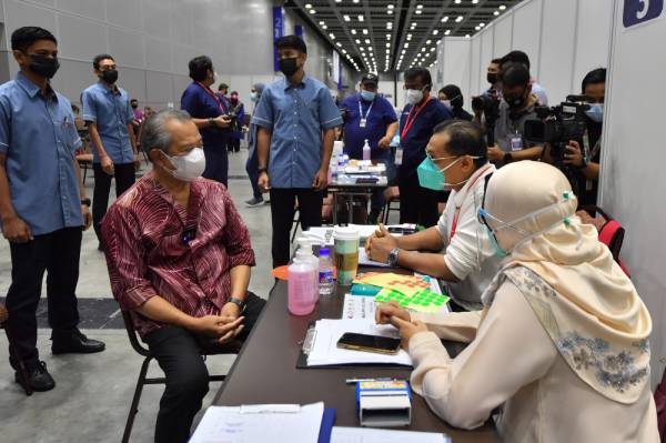 Perdana Menteri Tan Sri Muhyiddin Yassin ketika membuat lawatan ke Pusat Pemberian Vaksin (PPV) di Pusat Konvensyen Kuala Lumpur (KLCC) hari ini. -Foto Bernama