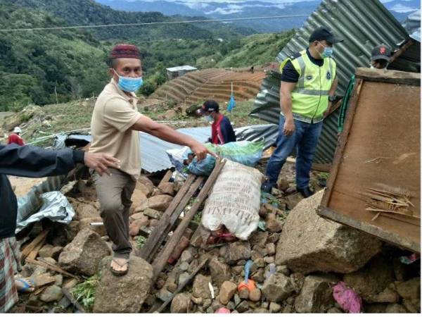 Penduduk kampung menunjukkan lokasi kejadian mangsa terperangkap dalam runtuhan batu di Kampung Pinousuk, Kundasang, Ranau. 