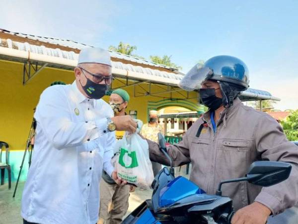 Razman menyerahkan agihan ayam kepada penduduk.