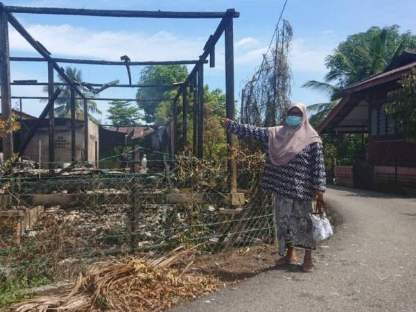 Rogayah menunjukkan rumahnya di Kuala Sungai Baru, Alor Gajah yang terbakar pada Isnin.