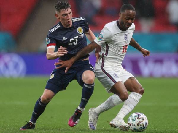 Gilmour (kiri) cuba mengekang kemaraan peledak Raheem Sterling semasa aksi kumpulan D Euro 2020 di Stadium Wembley pada 18 Jun. FOTO: AFP