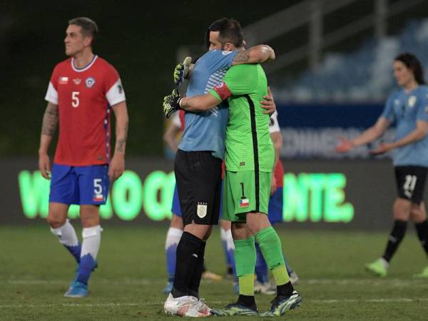 Bravo (kanan) berpeluk dengan pemain Uruguay selepas perlawanan tersebut.