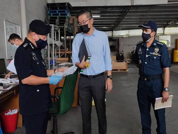 Eng Lai memeriksa dokumen berkaitan ke atas sebuah kilang di Segambut, Kuala Lumpur dalam operasi pemantauan SOP, pada Selasa.