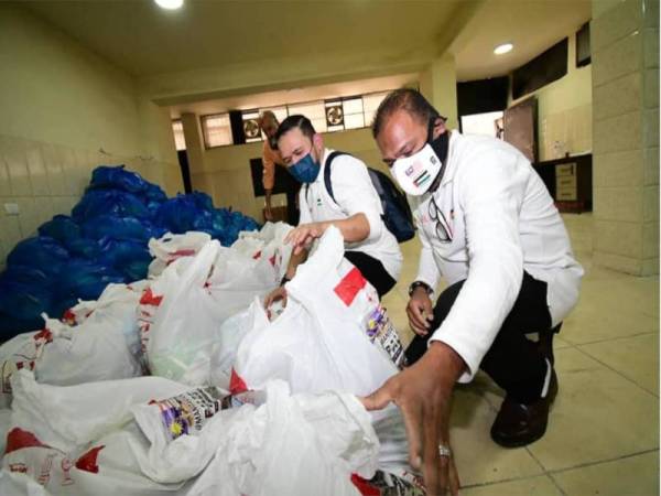 Abdul Azeez (kanan) melihat bekalan makanan dan keperluan harian yang disalurkan kepada 1,000 keluarga Palestin di empat kem pelarian di Jordan. - Foto UMNO Online 