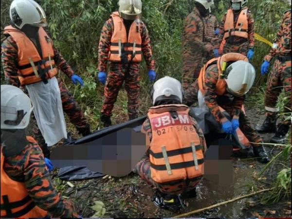 Anggota bomba mengangkat mayat yang ditemui dalam danau di Tasik Tanjung Labuh, Batu Pahat pada Selasa.