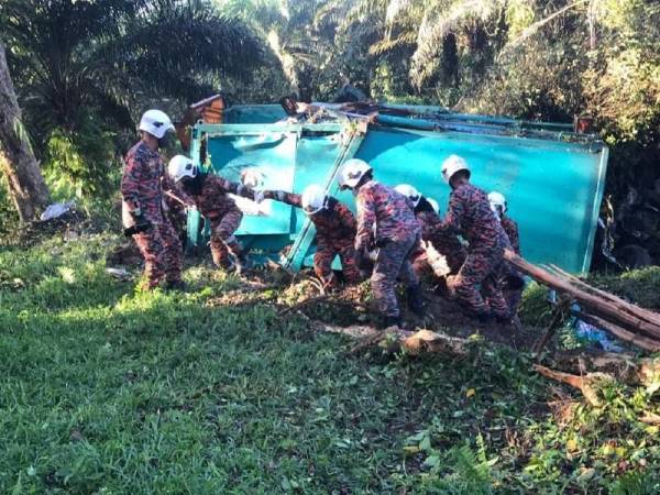 Anggota bomba mengangkat seorang pemandu yang cedera parah selepas lori sampah dipandunya terlibat kemalangan di Jalan Bandar Tenggara, Petrajaya, Kota Tinggi, pada Khamis.