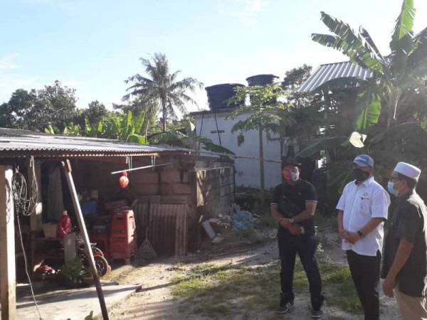 Che Zakaria meninjau keadaan sebuah rumah yang rosak akibat dipukul ribut di Kampung Plentong Baru, Pasir Gudang pada Khamis.