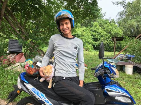 Muhammad Amir bersama haiwan peliharaan yang lebih mesra dipanggil 'Long' ayam hutan dan 'Adik Kiss' kucing ketika ditemui pemberita dirumahnya di Kampung Cherodok, pada Khamis. - Foto Bernama 