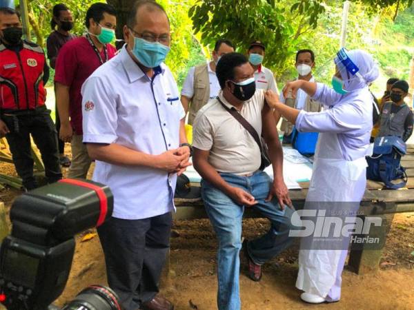 Ahmad Amzad (kiri) bersama Tok Batin Kampung Kluat, Kamal Gadong yang menerima suntikan vaksin jenis Sinovac pada Ahad. - FOTO: SINAR HARIAN