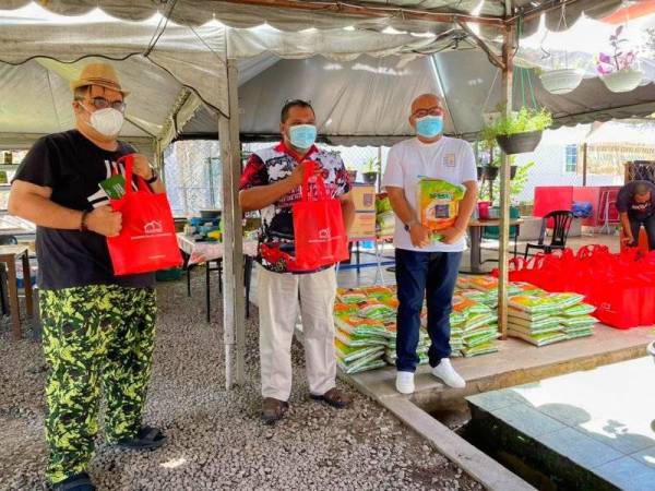 Tengku Ibrahim Farihaddin (kiri) menunjukkan sumbangan daripada Kumpulan Malvest dan YAKIN yang akan disumbangkan kepada golongan asnaf di negeri ini yang terjejas dengan serangan pandemik Covid-19.