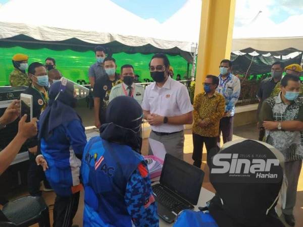 Wan Ahmad Fayhsal bertanyakan sesuatu kepada sukarelawan MyVac ketika meninjau Pusat Pemberian Vaksin (PPV) Dewan Dato' Zainal Abidin Zin, di sini pada Khamis.