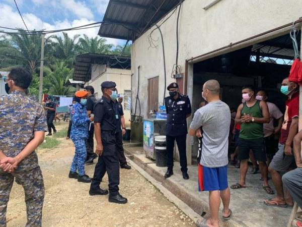 Srikumar (tengah) melakukan pemeriksaan dalam Penguatkuasaan Operasi Patuh di asrama pekerja asing di Kawasan Perindustrian Bukit Bakri, Muar pada Khamis.