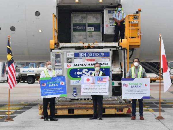 Hiroshi Oka (tengah) bersama Hishammuddin (kiri) dan Khairy menyaksikan ketibaan vaksin Astrazeneca sumbangan kerajaan Jepun di KLIA pada Khamis. - Foto Bernama