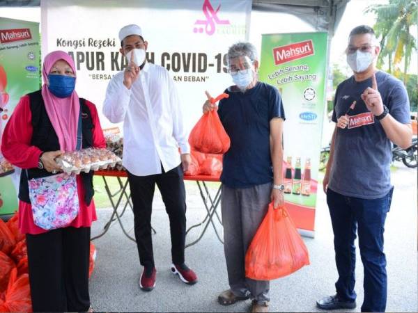 Fatini (kiri), Nabil dan Mohd Jazri (kanan) menyerahkan bakul makanan kepada wakil keluarga.