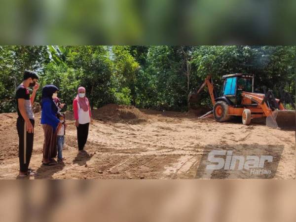 Nurfarra Asyikin (dua, kiri) bersama adik-adiknya melihat kerja-kerja merata tanah untuk membina kediaman baharu mereka di Kampung Pasir Puteh, Tualak, Kuala Nerang.