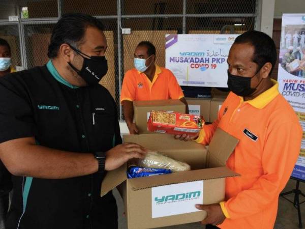 Tuan Kamarul Arief (dua dari kiri) menyampaikan bantuan kotak makanan kepada Zulkifli di bawah Program Yadim Peduli Musa'adah Covid-19 Yadim 3.0 di Depo Operasi Pembersihan MPSP Padang Cempedak, Jalan Permatang Manggis, Tasek Gelugor pada Sabtu. - Foto Bernama