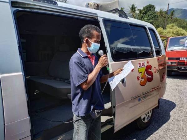 Ramli guna loghat tempatan bagi menarik penduduk di perkampungan orang asli Sungai Rual, Jeli hadir mendapatkan suntikan vaksin Covid-19.