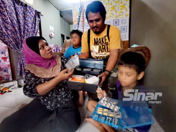 Siti Mariam (kiri) memberi ubat kepada suaminya Adi Futrizqi.