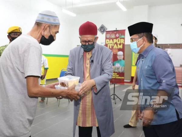 Zulkifli (tengah) menyampaikan bantuan Dapur It'am 5.0 kepada salah seorang penerima di Surau Al-Falah Projek Perumahan Rakyat (PPR) Ampang Hilir pada Ahad.