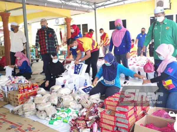 Noh (dua dari kiri) meninjau proses pengagihan bakul makanan Parlimen Tanjong Karang pada Isnin.