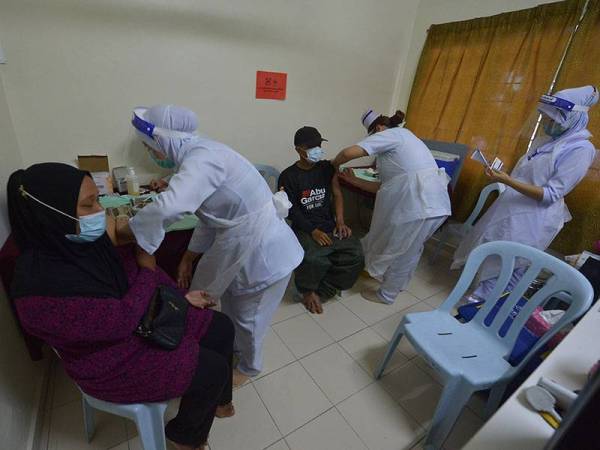 Masyarakat orang asli menerima suntikan Vaksin pada Program Pemberian Vaksin Bergerak kepada komuniti Orang Asli daerah Sepang di Balairaya Kampung Sungai Buah, Jalan Sungai Buah Luar, Dengkil hari ini. -Foto Bernama