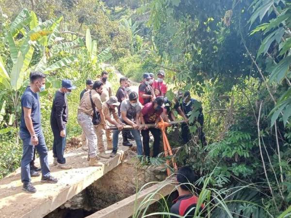 Anggota penguat kuasa sedang membaiki jambatan bagi membolehkan operasi memusnahkan kebun haram dilakukan di Hutan Simpan Kekal Batu Talam, Raub. - Foto ihsan JPNP