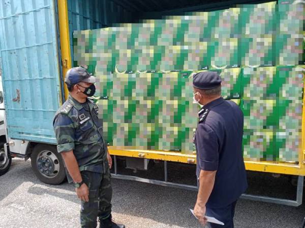 Muhammad (kiri) menunjukkan arak yang dirampas ketika sidang akhbar di Ibu Pejabat Polis Daerah Shah Alam pada Khamis.