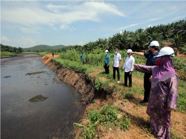 Ahmad Nasim (dua dari kanan) bersama Samsiah (kanan) dan Razali (tiga, kanan) meninjau keadaan kolam rawatan sisa sawit di sebuah kilang kelapa sawit dipercayai mengakibatkan menjadi punca kepada pencemaran di Sungai Pukin, pada Jumaat. - Foto Bernama 