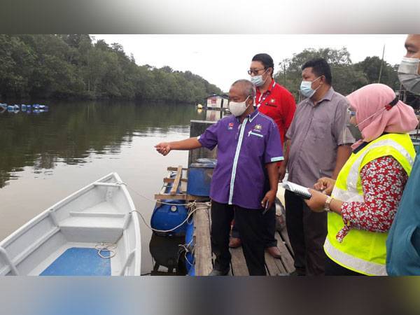 Othman (depan) dan kakitangan JAS meninjau keadaan air kotor dan berbau akibat pencemaran di Sungai Kopok, Kampung Perigi Acheh, Pasir Gudang pada Khamis.