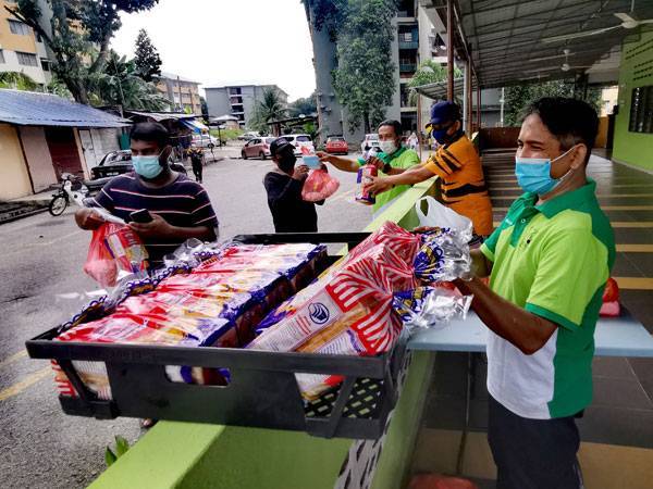 Ahli Jawatankuasa Masjid Al-Azim Taman Semarak mengagihkan bantuan makanan kepada penduduk warga asing