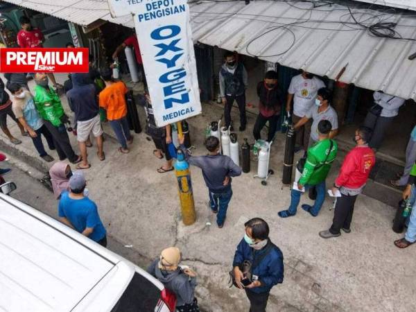 Orang ramai mengerumuni sebuah kedai mengisi semula tabung oksigen di Jakarta pada 30 Jun lalu. - Foto AFP